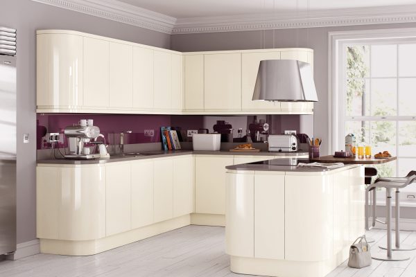 Contemporary kitchen design featuring cream gloss handleless cabinets and integrated soft-closing drawer units.