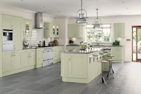 Soft sage green shaker kitchen with traditional cabinetry, integrated appliances, and a light, welcoming atmosphere created by natural wood accents.