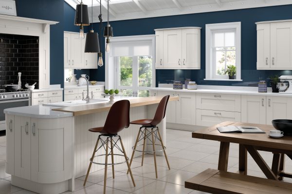 A luxury white shaker kitchen with silver handles, light countertops, and a central island that feels bright and sophisticated.